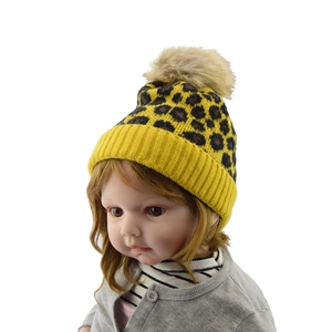 Detailed knit texture and beige faux fur pom-pom on yellow leopard print baby beanie