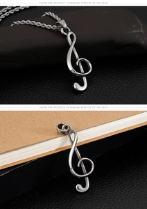 Detailed view of a silver G-clef music note pendant with a durable steel rope chain