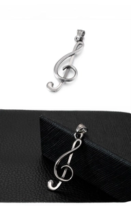 Macro shot of polished stainless steel treble clef music pendant on leather texture