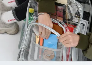 Detail of transparent PVC backpack showing spacious compartments with gray webbing and zipper
