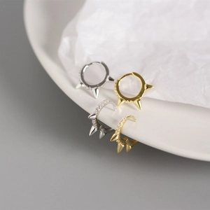 Macro shot of punk style sterling silver hoop earrings with spikes and pave zircons