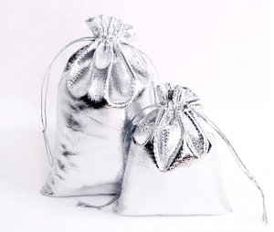 Detail view of silver metallic drawstring gift bags with textured shimmering fabric