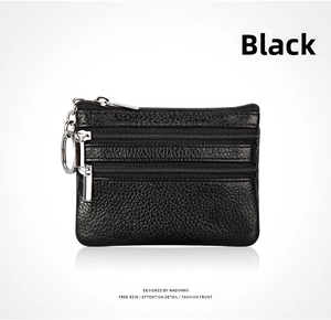 Macro shot of black genuine leather coin purse with three zippers and metal keyring