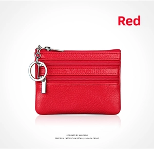 Macro detail of red genuine leather coin purse with three zipper sections and metal keyring
