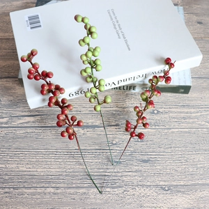 Artificial orange berry branches on a book, perfect for DIY home and table decor
