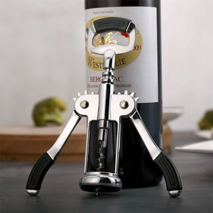 Close-up of a premium wing corkscrew bottle opener with black non-slip grips on a wine bottle