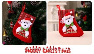 Détail d'une chaussette de Noël rouge avec ours 3D et broderie Merry Christmas sur tissu