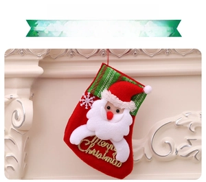 Détail de chaussette de Noël rouge avec figurine Père Noël 3D et texte Merry Christmas doré
