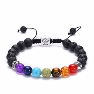 Dettaglio macro delle 7 perle chakra e ciondolo albero della vita su bracciale lava