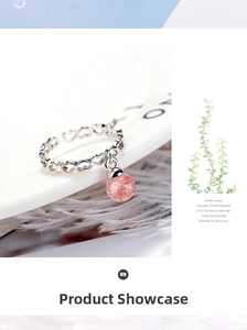 Detail of pink strawberry quartz ball pendant on hollow heart pattern silver ring
