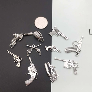 Antik-silberne Waffen-Anhänger aus Metall für DIY-Schmuck auf zweifarbigem Hintergrund