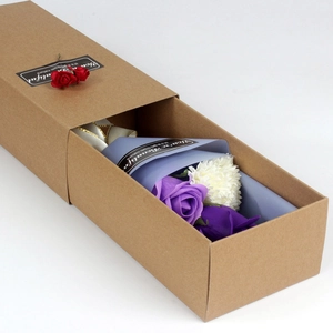 Macro view of purple artificial carnation bouquet in a kraft paper drawer gift box