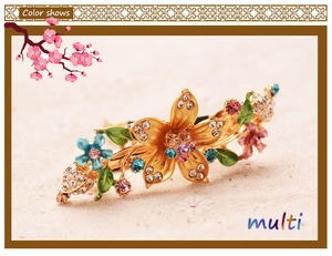 Detailed view of vintage flower hair clip with colorful rhinestones and green enamel petals