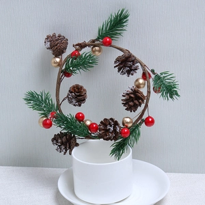 Small Christmas wreath with pine cones and red berries on a white decorative stand