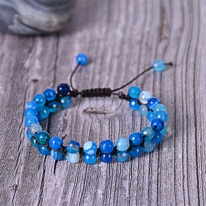 Detail of bohemian double-layered blue agate beaded bracelet on a vintage wood surface