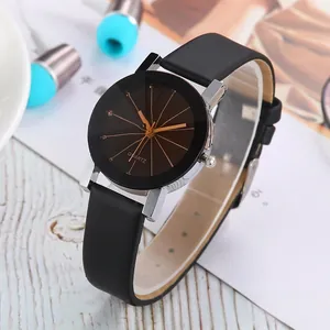 Close-up of minimalist black dial quartz watch with silver casing and black leather strap