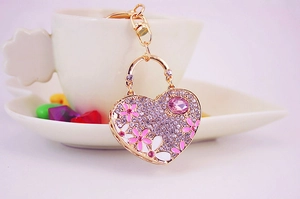 Close-up of heart keychain with purple rhinestones, pink flowers and metal clasp