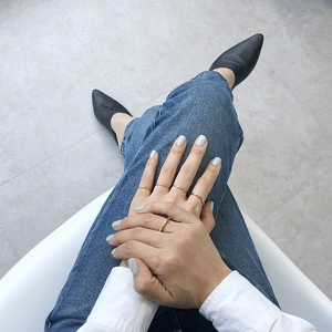 Close-up of minimalist thin gold silver rings worn by a model in a lifestyle setting