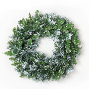Green Christmas wreath with artificial pine needles and snowy finish for holiday decor