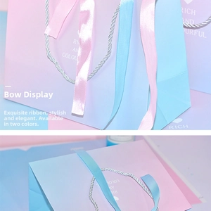 Detail of elegant pink and blue gradient gift bag with silver handle and satin ribbon bow