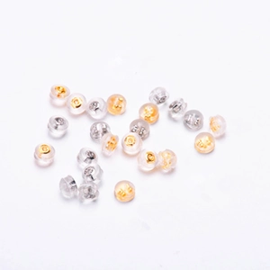 Macro shot of assorted gold and silver butterfly earring backs in clear silicone casings