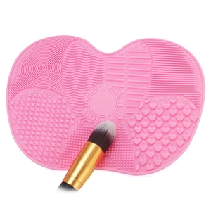 Detailed view of pink silicone makeup brush cleaning mat with varied texture zones