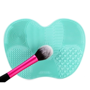 Detailed view of mint green silicone brush cleaner mat showing textured washing zones