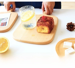 Overhead view of a beech wood cutting board with handle and clear natural grain texture