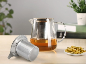 Detail of 304 stainless steel tea infuser inside a heat-resistant glass teapot on wood
