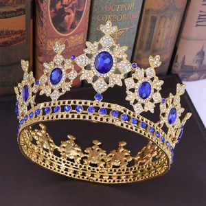 Detail of golden baroque crown with blue gemstones and rhinestones on vintage books