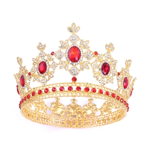 Close-up of golden crown with red oval gemstones and sparkling crystal embellishments
