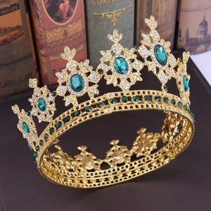 Detail of golden Baroque crown with green emeralds and crystals on vintage books