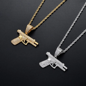 Close-up of hip hop pistol necklaces in gold and silver finish with AAA cubic zirconia