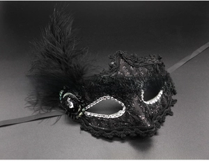 Detail of black lace masquerade mask with feathers, sequins and faux diamond trim