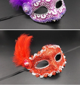 Detail of purple and red lace masquerade masks with decorative feathers and sequins