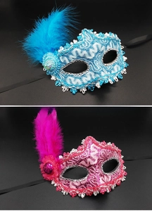 Detail of blue and pink lace party masks with tall feathers and shiny sequins