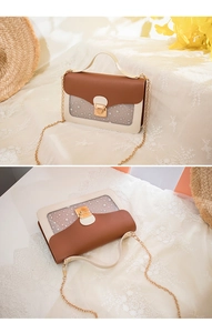 Detail of crossbody bag with star pattern, metal chain strap and golden lock