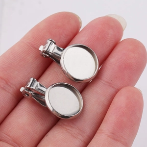 Close-up of silver stainless steel clip-on earring findings being held on a hand