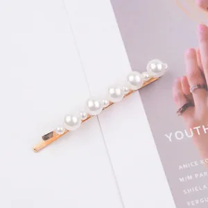 Detailed view of 7cm pearl hair clip with gold metal base and various pearl sizes