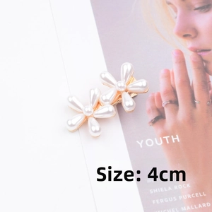 Detailed close-up of 4cm double pearl flower hair clip with golden alloy base