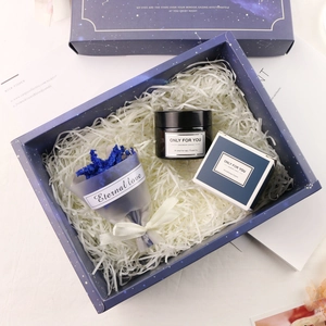 Blue gift set with brown jar soy candle, matching paper box and dried flowers on raffia