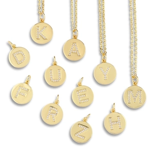 Gold plated round disk necklaces featuring minimalist rhinestone initial pendants