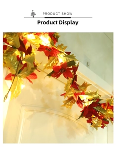 Detailed view of warm LED lights on red poinsettia flowers and gold leaf Christmas garland