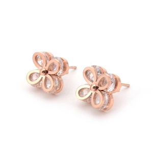 Rose gold clover earrings with white zircon inlays on a minimalist white background