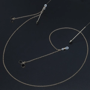 Elegant gold metal glasses chain with a black sunglasses pendant on a dark background