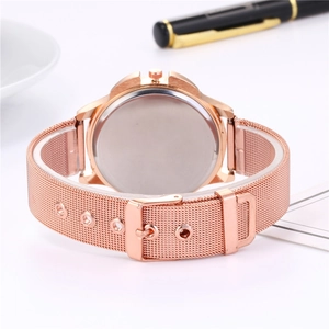 Élégante montre à quartz rose gold pour femme avec bracelet en maille sur un bureau