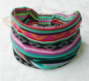 Detail of bohemian wide headband with vibrant geometric patterns on white faux fur