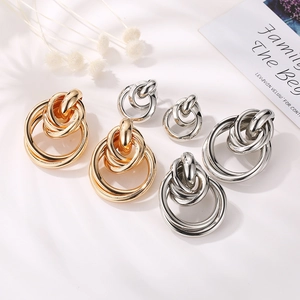 Interlocking geometric hoop earrings in gold and silver finish with high polished metal surface