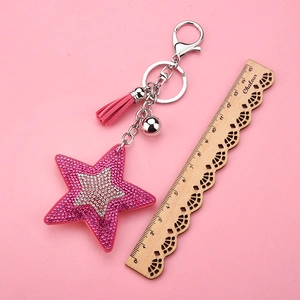 Détail du porte-clés étoile à paillettes roses avec pompon et clochette argentée de 15cm