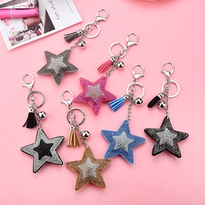 Porte-clés étoile à paillettes avec pompons en cuir de plusieurs couleurs sur fond rose